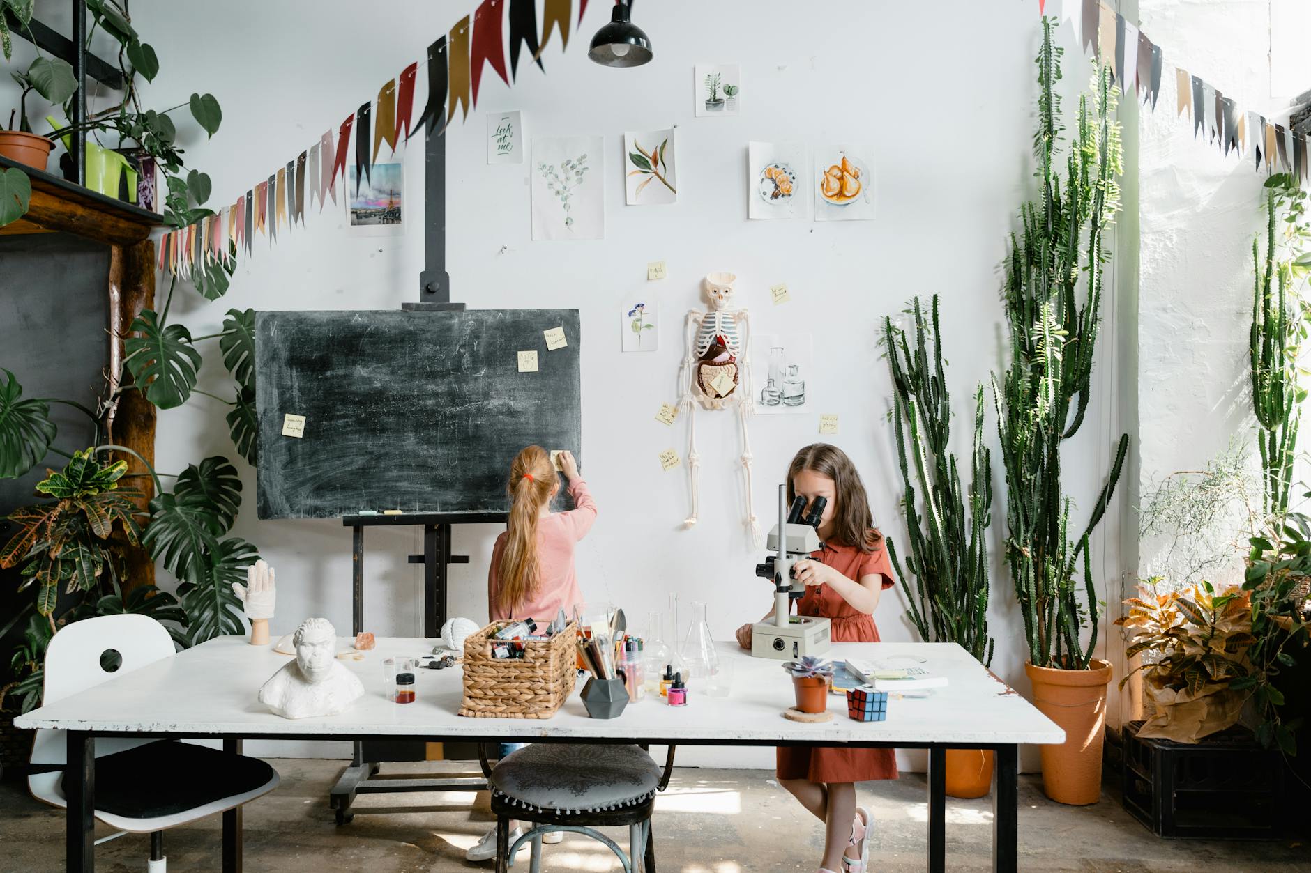 Dwie dziewczynki oglądają pod mikroskopem preparaty w klasie biologii
