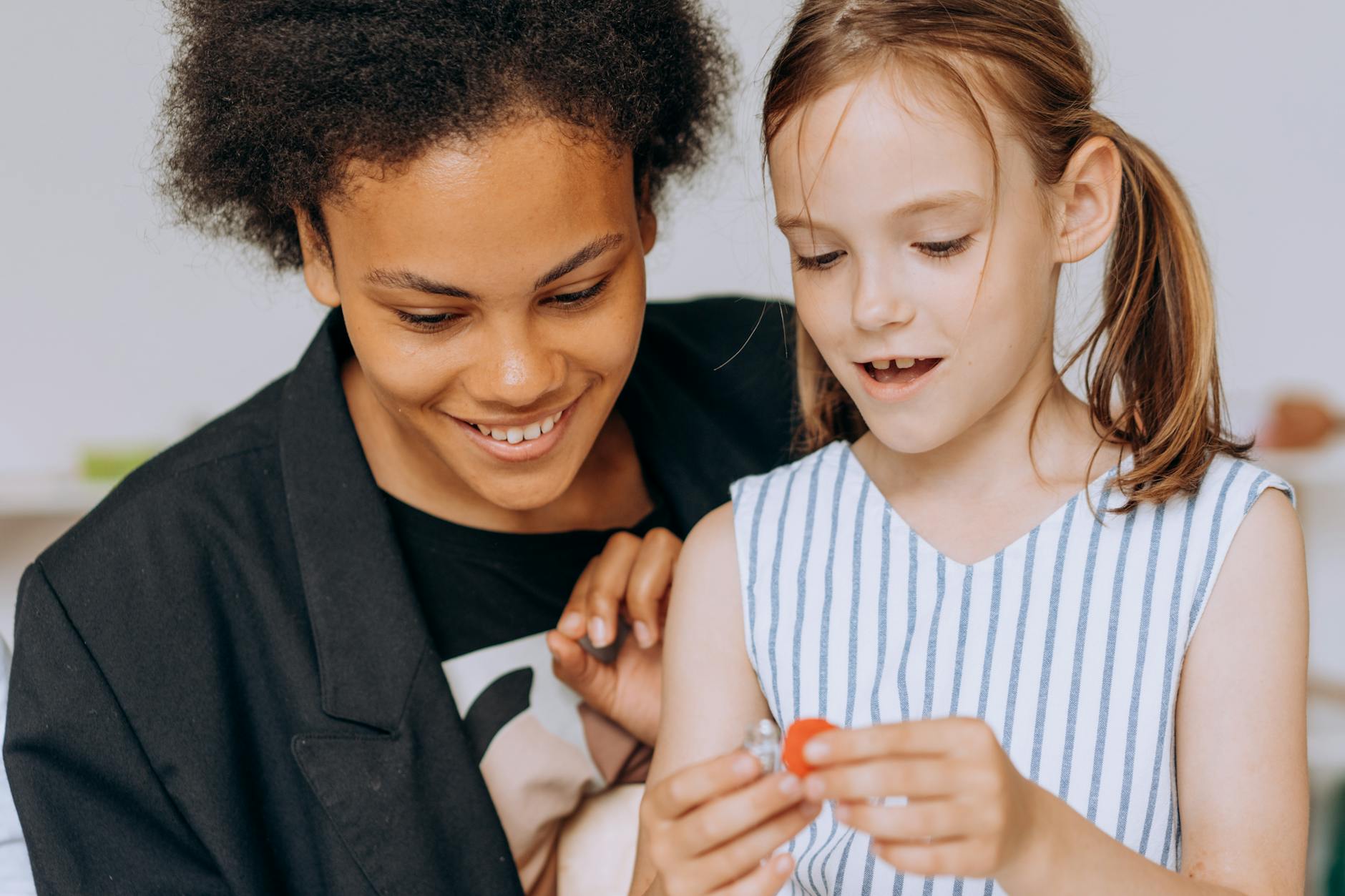 Nauczycielka wspierająca uśmiechnięte dziecko podczas zajęć w klasie