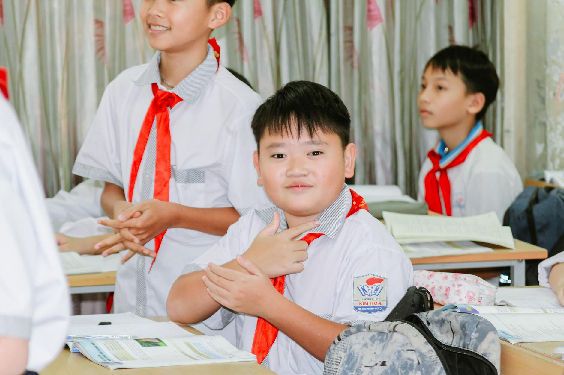Uśmiechnięci azjatyccy studenci współpracujący przy zajęciach w klasie