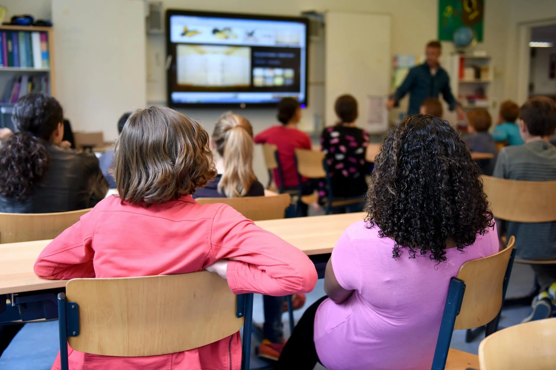 Uczniowie w holenderskiej klasie oglądają lekcję na tablicy multimedialnej