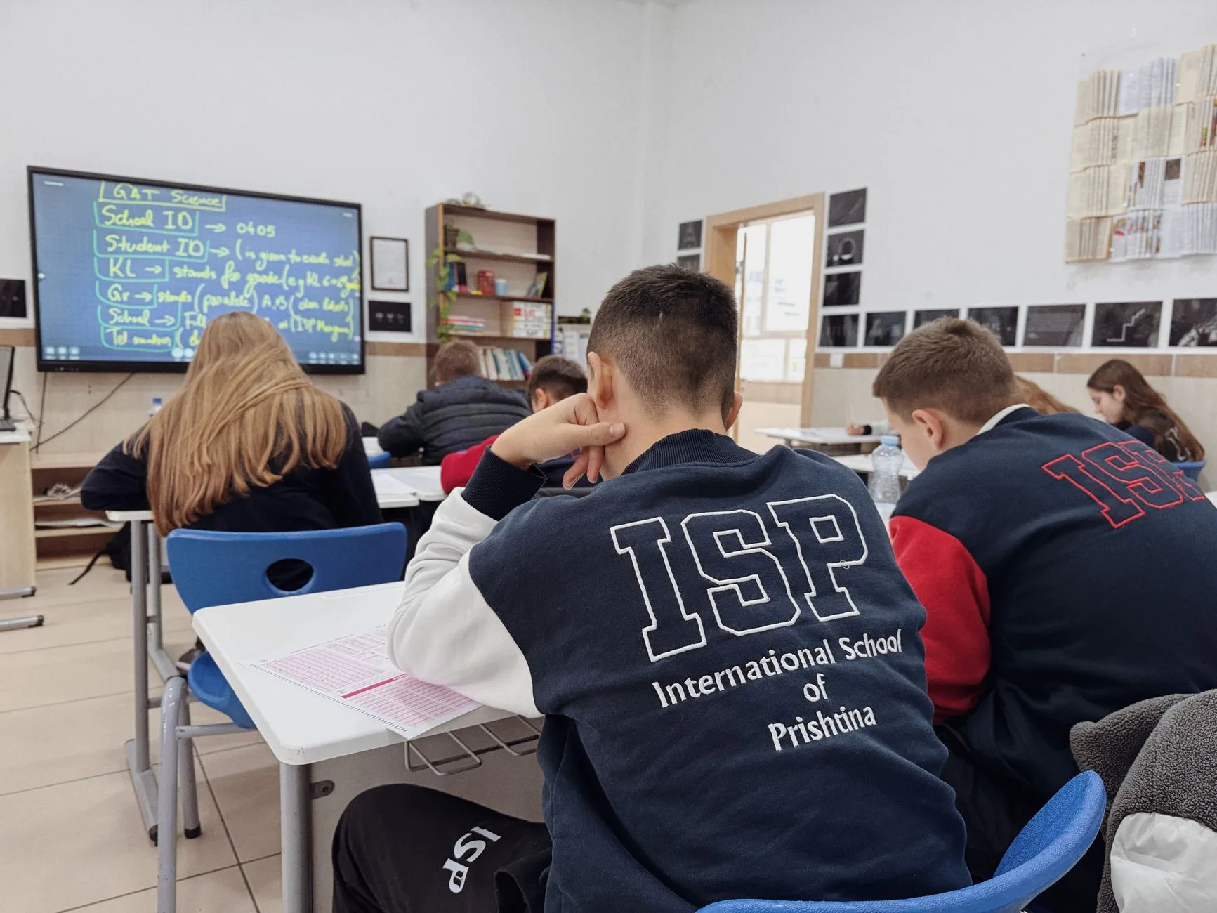 Uczniowie słuchający nauczyciela podczas lekcji w nowoczesnej klasie